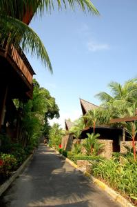 an empty road with palm trees and a building at Batam View Beach Resort in Nongsa