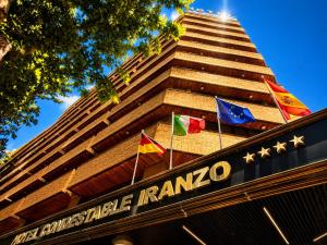 a building with three flags on the front of it at Hotel Condestable Iranzo in Jaén