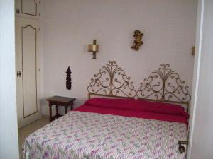 1 dormitorio con 1 cama con colcha roja y blanca en By Jonni Res. Chaparral, en Costa del Silencio