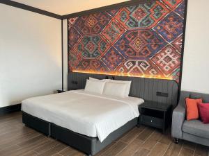 a bedroom with a bed with a painting on the wall at Bangi Resort Hotel in Bangi