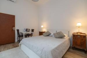 a bedroom with a bed and a desk and a table at Apartment and Rooms Stay in Dubrovnik