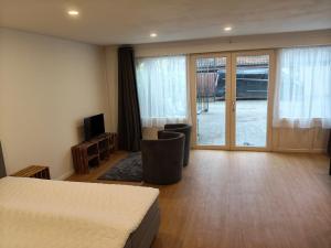 a bedroom with a bed and a sliding glass door at La Clé des Champs in Jodoigne