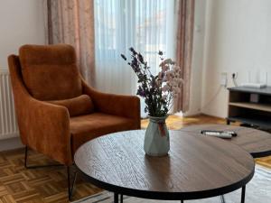 a vase of flowers on a table in a living room at Apartments & Spa - Insula Vita in Bihać