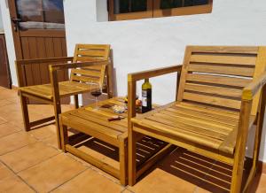 two chairs and a table with a glass of wine at LUANA APARTMENT in Teguise