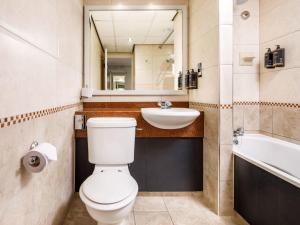 a bathroom with a toilet and a sink and a mirror at Mercure Chester Abbots Well Hotel in Chester +94 photos