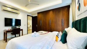 a bedroom with a large white bed and a television at Hotel Marina Premium Near IGI Airport Delhi in New Delhi