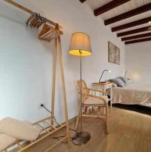 a room with a lamp and a chair and a bed at LUANA APARTMENT in Teguise