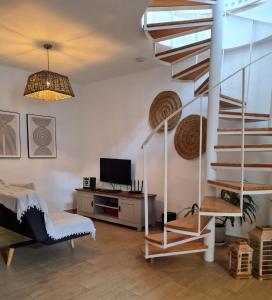 a living room with a spiral staircase and a tv at LUANA APARTMENT in Teguise