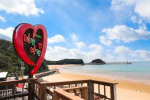 a red heart sign on a beach with the ocean at Nuhrang Nahrang in Taean +16 photos