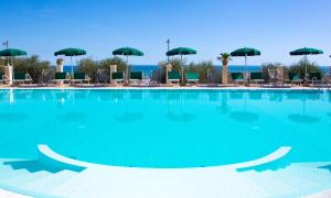 a large swimming pool with chairs and umbrellas at Residence Chiesiola in Vieste