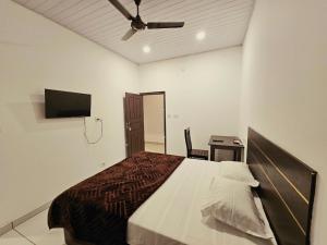 a bedroom with a bed and a ceiling fan at Thekkady Nest Residency in Thekkady