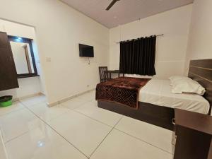 a bedroom with a bed and a tv in it at Thekkady Nest Residency in Thekkady