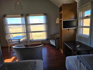 a room with a bed and a desk and a tv at Dæli Apartments in Víðidalstunga
