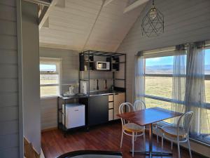 a kitchen and dining room with a table and chairs at Dæli Apartments in Víðidalstunga