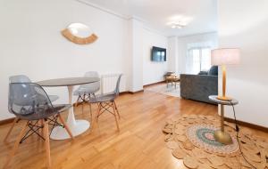 a living room with a table and chairs and a couch at Apartamentos El Escudo Centro in Ribadesella