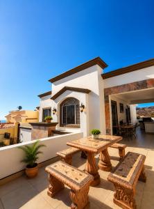 a patio with a table and benches on a balcony at Oceanview house in El Suazal