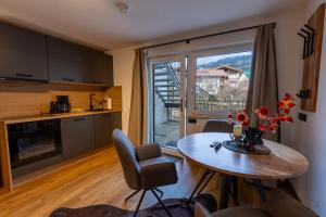 a kitchen and dining room with a table and a window at Alpen Lodge Kirchberg in Kirchberg in Tirol