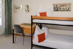 a room with two bunk beds and a desk at Edelweiss in Arosa