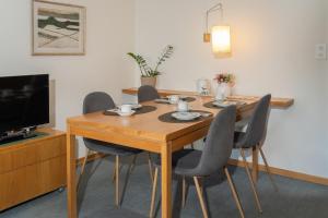 a dining room table with chairs and a television at Edelweiss in Arosa