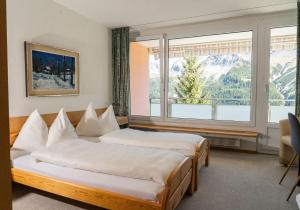 a hotel room with two beds and a window at Edelweiss in Arosa