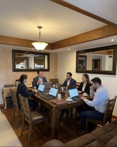 a group of people sitting around a table with laptops at Oceanview house in El Suazal