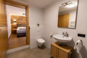 a bathroom with a sink and a toilet and a bedroom at Alpen Lodge Kirchberg in Kirchberg in Tirol +81 photos