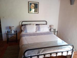 a bed in a bedroom with a picture on the wall at La Bergerie en Provence in Puimichel +10 photos