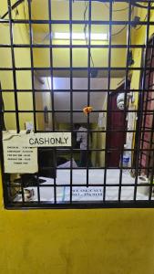 a view through a window of a prison cell with a sign at kiwi budget hotel in Rawang