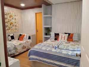 a bedroom with two beds and a book shelf at Charming House with Private Pool in Bacolod