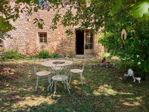 a table and chairs in front of a stone building at La Bergerie en Provence in Puimichel