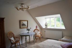 um quarto com uma mesa e cadeiras e uma janela em Fuglsø Kro Bed & Breakfast em Knebel