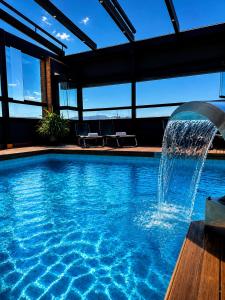 a swimming pool with a fountain in a building at Hotel Condestable Iranzo in Jaén