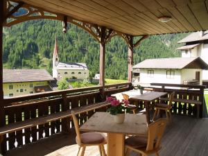 a wooden table and chairs on a deck with a view at Oberwirt in Selva dei Molini