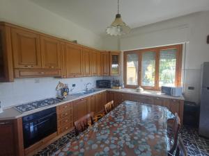 a kitchen with wooden cabinets and a table in it at A casa di Nonna in Gambassi Terme