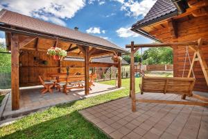 a wooden pavilion with a picnic table and benches at Drevenica Horehronka in Závadka nad Hronom +36 photos