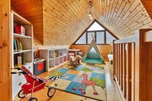 a childs room with a wooden ceiling and a large rug at Drevenica Horehronka in Závadka nad Hronom
