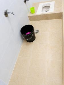 a bathroom with a sink and a black bucket at Hotel Rajmahal in Ajmer
