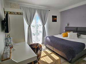 a bedroom with a bed and a desk and a window at Boutique Resort OSMA - Adults Only in Malinska +100 photos