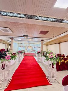 a red carpeted aisle with a red carpet and flowers at Mak Palace Hotel in Sialkot