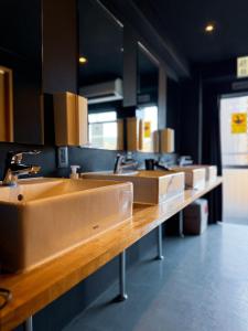 a row of sinks in a public bathroom at GuestHouse Hostel MangeTak ゲストハウス マングタック広島 in Hiroshima