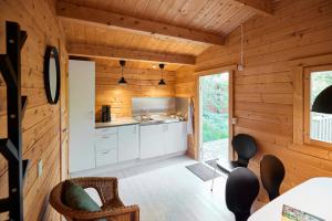 a kitchen in a cabin with wooden walls at Fårup Skovbrynet in Saltum