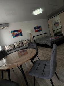 a living room with a couch and a table and a bed at Однокомнатная квартира в центре города in Balqash +16 photos