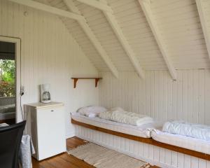 a room with two beds in a white room at Fårup Skovbrynet in Saltum