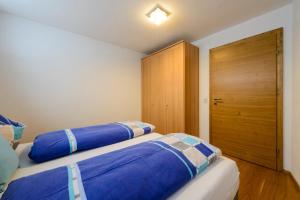 - une chambre avec 2 lits et une armoire en bois dans l'établissement Appartement Kufsteinblick, à Haus im Ennstal