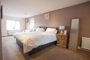 a bedroom with a large bed and a mirror at The White Swan Inn in Lowick
