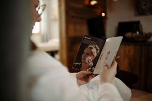 a man is reading a book in bed at Chaletdorf Auszeit in Hüttschlag