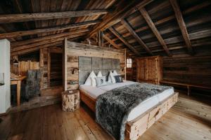 a bedroom with a bed in a log cabin at Chaletdorf Auszeit in Hüttschlag