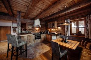 a kitchen with a table and chairs in a cabin at Chaletdorf Auszeit in Hüttschlag