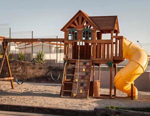 a playground with a slide and a play structure at Oceanview house in El Suazal