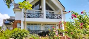 a white house with trees in front of it at Blue Water Resort in Diani Beach